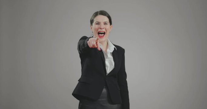 businesswoman laughs badly and points with finger