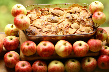 pieces of fresh baked apple pie among raw apples country style still life