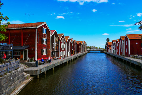 Hudiksvall, Sweden People sitting among old fishermen boathouses on the Sundskanalen, or Sund Canal, also known as Moljen.