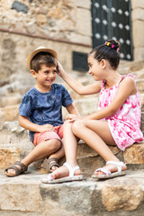 Two kids playing on a stairs of a rustic village