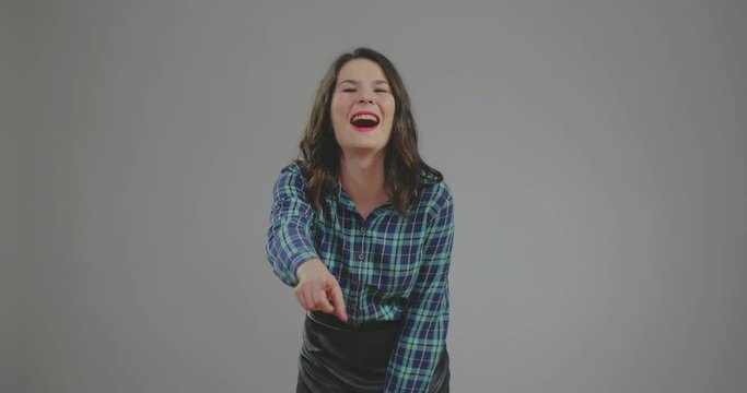 beautiful girl laughs badly and points with finger