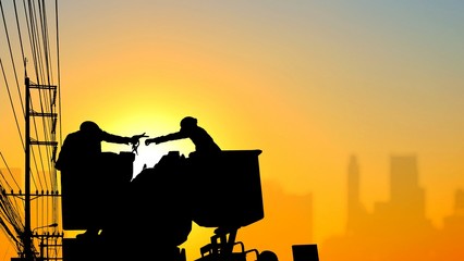 Silhouette low angle view of two electricians on electric cable car lifts are working to install electrical transmission and blurred buildings shadow in sunrise sky background, illustration mode