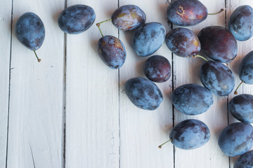 Freshly picked and delicious blue plums on wooden table