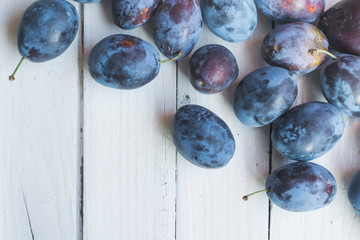 Freshly picked and delicious blue plums on wooden table