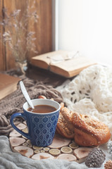 Fototapeta na wymiar Coffee in a blue mug on the windowsill in autumn winter