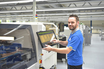 Naklejka na ściany i meble Arbeiter in einer modernen Fabrik bedient Maschine - Portrait Mann am Arbeitsplatz