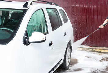 The process of washing a white car using a pressure washer