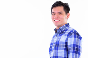 Closeup profile view of happy young Asian hipster man looking at camera