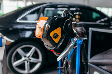 Fototapeta premium Welding equipment close up in a car repair station on car background