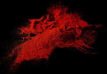 Dry red spicy pepper, paprika powder isolated on black background