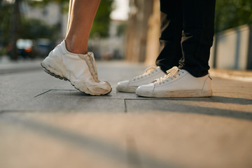 girls stands on tiptoe to kiss her man - Close up on shoes © makistock