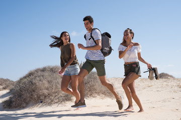 Three young people running and laughing