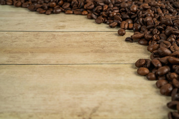 Coffee beans frame with beans at the bottom and top side on a oak wooden  background