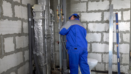 Master, worker checks the water meter in the apartment