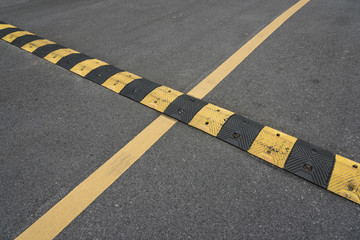 Fototapeta premium Yellow paint line and speed bump line on asphalt road