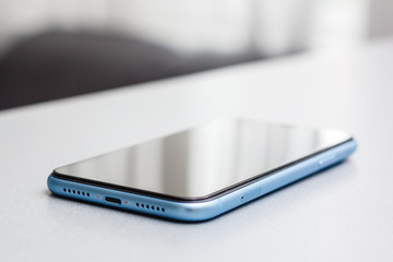 mobile on wooden desk with nobody in the room