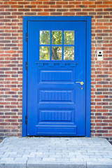 blue wooden front door in a brick wall