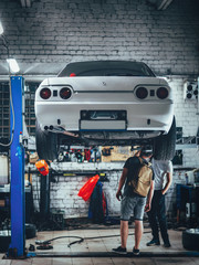 Night car service. Sport drift car on the lift. Suspension inspection and repair © pavelkant