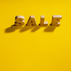 Close-up view of sale word on yellow background