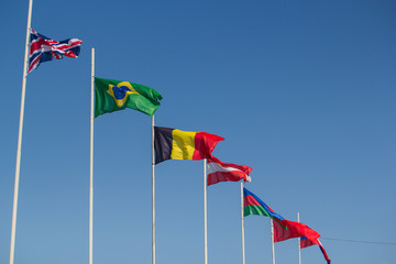 Flags of the world countries blowing in the wind on a background of the blue sky