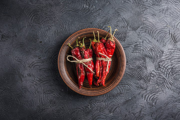 Spicy chili on a dark background in ceramic plates, flatlay.