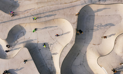 Skate park top view. Young people doing sport riding skaters bicycles and scooters. Aerial top view. Creative Street photo new concept