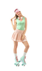 Beautiful young woman on roller skates against white background