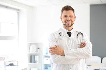 Naklejka na ściany i meble Male doctor with stethoscope in clinic