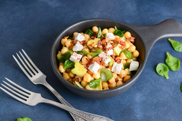 Bowl with tasty chickpea salad on table