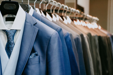 Men suit jackets on hanger in a shop