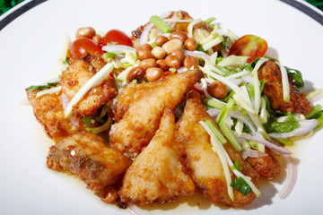 Hot and spicy sour Thai Salads. With  Fried Fish and Chopped Mango. Sea bass.