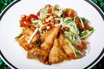 Hot and spicy sour Thai Salads. With  Fried Fish and Chopped Mango. Sea bass.