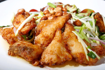 Hot and spicy sour Thai Salads. With  Fried Fish and Chopped Mango. Sea bass.