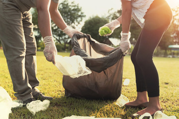 young people picking up garbage plastic for cleaning at park