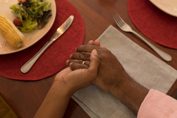 Father and daughter praying before having meal