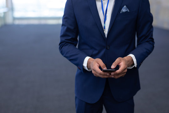 Elegant businessman using mobile phone in modern office