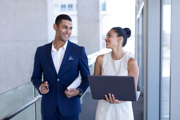 Young mixed-race business people interacting with each other in modern office