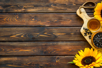 Fresh sunflower oil with seeds and flower frame on wooden background top view mock up