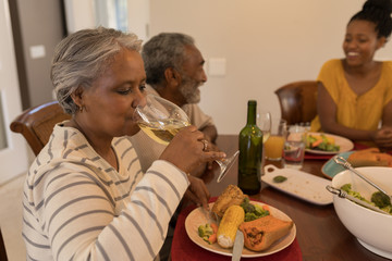 Multi-generation African American family eating dinner on dining table at home