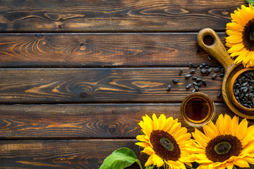 Sunflower with seeds and oil frame on wooden background top view copyspace
