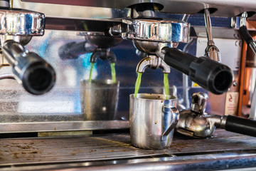Green tea pouring machine into cup close up