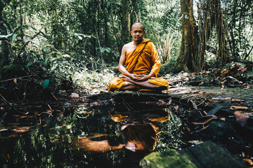 Meditation of buddha monk in deep forest with river