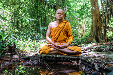 Meditation of buddha monk in deep forest with river