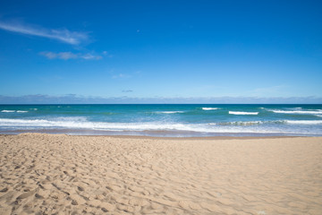 front view of seashore of Palmar Beach with sand, turquoise ocean water and horizon in Vejer village (Cadiz, Andalusia, Spain)