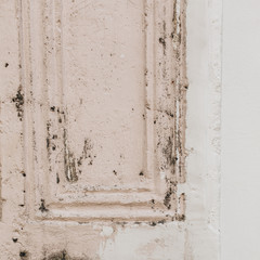 An old shabby pale pink and white door. Vintage and retro concept. Neutral background.