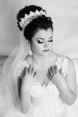 Young gorgeous bride is sitting in couch. Trendy wedding style shot. Young attractive a bride tender looking. Bride in beautiful dress sitting in home. Wedding. Sexy bride.  Black and white.