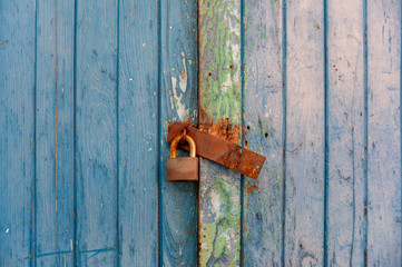 Closeup old rusty lock on the door and broken wood of lock. wood background.