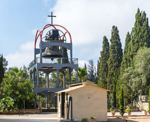 The metal bell tower with a large bell in the courtyard of the Greek Orthodox Monastery of the...