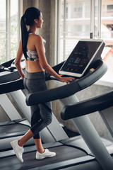 Obraz premium Asian woman jogging on treadmill in the gym fitness club.