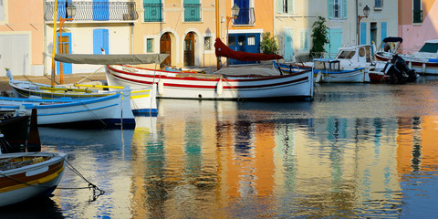 Fototapeta na wymiar facade of mediterranean building with colorful shutter with river and boat